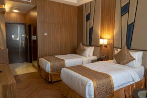 a hotel room with two beds and a bathroom at Golden Tower Hotel AlKhobar Corniche in Al Khobar