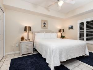 a white bedroom with a white bed and a window at Summerwind in Navarre