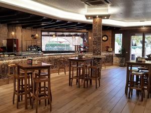 a restaurant with wooden tables and chairs and a bar at Complejo Turístico Las Cañadas Casas de Campo- Actividades Gratuitas Todos los Fines de Semana in Baños de Montemayor