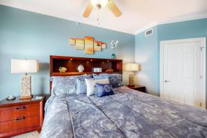 1 dormitorio con 1 cama grande y paredes azules en Summer Place, en Fort Walton Beach