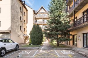 une voiture garée dans un parking en face d'un bâtiment dans l'établissement El Refugio de Aran Vielha Aparthotel, à Vielha e Mijaran