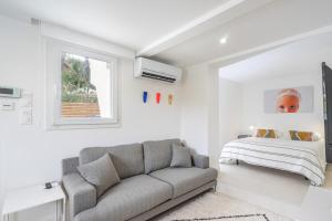 een woonkamer met een bank en een bed bij Giovannina-N1 in Cassis