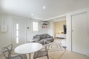 een witte woonkamer met een tafel en een bank bij Giovannina-N1 in Cassis