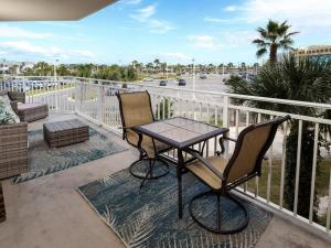 a table and two chairs on a balcony with a view of a parking lot at Waterscape A II in Fort Walton Beach