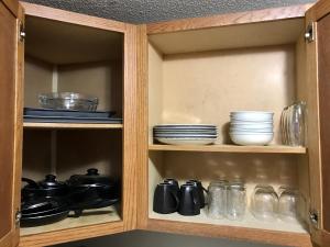 a cabinet filled with dishes and bowls and plates at Cozy Mother-in-Law Apartment in Osceola