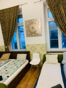 dwa łóżka w pokoju z dwoma oknami w obiekcie Modern Classic on Kiraly w Budapeszcie