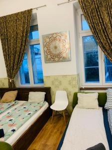 two beds in a room with two windows at Modern Classic on Kiraly in Budapest