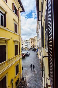 two people walking down a street between two buildings at LUXURY SWEET HOME FARNESE - CAMPO DEI FIORI in Rome