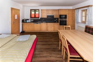 una cocina con una gran mesa de madera y sillas en Appartement Unterhof, en Wagrain