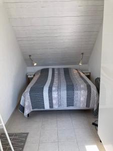 a small bedroom with a bed in a attic at Villa Blanche in Tofta