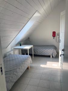 a attic room with two beds and a table at Villa Blanche in Tofta