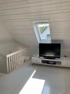 een woonkamer met een flatscreen-tv en een raam bij Villa Blanche in Tofta