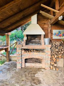 einem Backsteinofen im Freien mit einem Holzhaufen in der Unterkunft Casa della Montagna - Baita delle Rondini in San Giovanni in Fiore