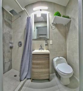 y baño con aseo, lavabo y ducha. en Villas Marlin 2, en Cancún