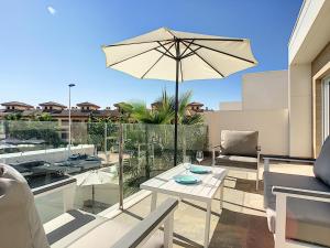 a patio with a table and an umbrella on a balcony at Villa Sol - San Pedro del Pinatar - 1710 in San Pedro del Pinatar