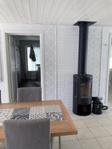 sala de estar con chimenea, mesa y fogones en Villa Blanche, en Tofta