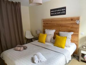 a bedroom with two beds with yellow and white pillows at Le Gîte de Sandra in Ribeauvillé