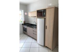 uma pequena cozinha com um frigorífico e um lavatório em Residencial Gaivotas 05 - 1 Quartos - Completo 30m da praia em Florianópolis