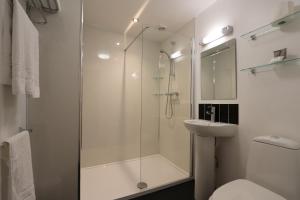 a bathroom with a shower and a toilet and a sink at Portbyhan Hotel in Looe