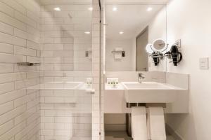 a white bathroom with a sink and a shower at Grand Mercure Sao Paulo Vila Olimpia in Sao Paulo +104 photos