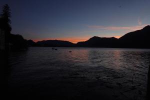 una puesta de sol en un lago con montañas en el fondo en Casa Rosa, en Dervio