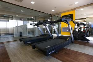 a gym with three tread machines in a room at Transamerica Fit Recife in Recife