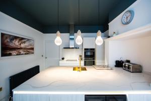 cocina con 2 luces colgantes y encimera en Rounton Villa by Maison Parfaite - Hot Tub - Sea Views - Parking, en Robin Hood's Bay