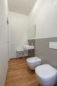 a bathroom with a white toilet and a sink at ForliHouse in Forlì