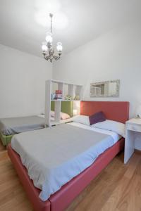 a bedroom with two beds and a chandelier at ForliHouse in Forlì
