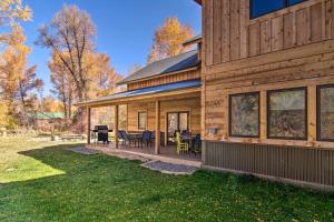 a wooden house with a patio and a yard at Riverfront Home with BBQ 2 Mi to Downtown Gunnison! in Gunnison