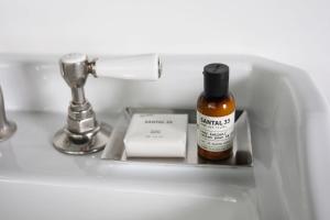 a bottle of essential oils sitting on a bathroom sink at The Robey in Chicago