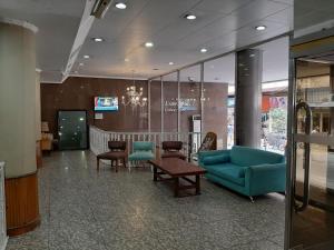 a waiting room with blue chairs and a table at Esmeralda Palace Hotel in Buenos Aires