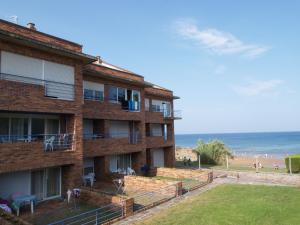 a brick building with the ocean in the background at Apartamentos Zenit Mar in Noja