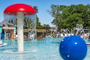 a fountain in a pool with a red ball at Bridges Bay Resort in Arnolds Park +37 photos