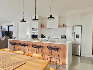 a kitchen with white cabinets and a table and chairs at Lake House - Te Anau Holiday Home in Te Anau