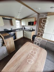 a living room with a kitchen and a table at Flamingo Land - Cedar Wood CW49 in Kirby Misperton