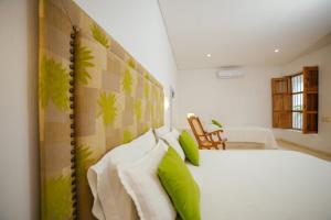 a bedroom with a white bed with green pillows at Bioma Boutique Hotel in Mompos +55 photos