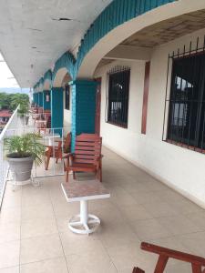 Un balcón con sillas y mesas en un edificio en Arcos hotel, en Catemaco