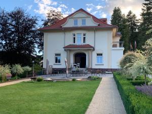 una gran casa blanca con un patio de césped en Residenz im Park, en Friedrichroda