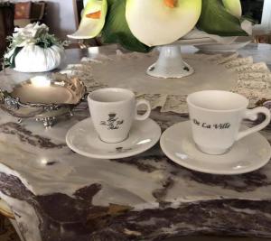 フィウミチーノにあるホテル デ ラ ヴィレ ルレーの大理石のテーブルにコーヒーカップ2杯とソーサー