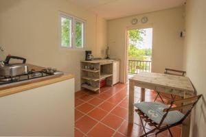 a kitchen with a table and a sink and a stove at Smileys Apartment in Willemstad