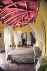 切普拉諾的住宿－Agriturismo ciociaro " il colle " HOTEL RISTORANTE，卧室配有一张带白色窗帘的大床