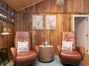 a living room with two chairs and a table with a stump at 6 person holiday home in Ulfborg in Fjand Gårde