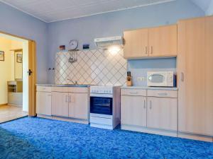a kitchen with white cabinets and a blue rug at Cozy Farmhouse in Benenden with Terrace in Teßmannsdorf
