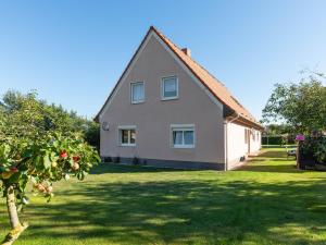 a house with a green yard with a tree at Cozy Farmhouse in Benenden with Terrace in Teßmannsdorf