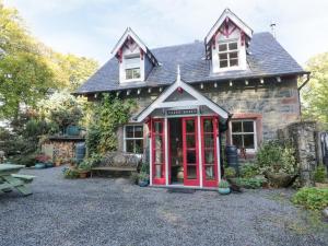 a house with a red phone booth in front of it at The Coach House in Newton Stewart