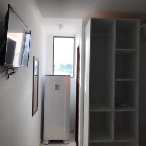 un réfrigérateur blanc dans une pièce avec une fenêtre dans l'établissement Pousada Unique Porto de Galinhas, à Porto de Galinhas