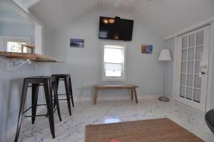 a living room with stools and a tv on the wall at Baby Love Shack in Salisbury