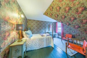 1 dormitorio con cama y papel pintado con motivos florales en Belle Femme, en Salem