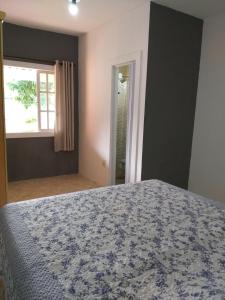 1 dormitorio con cama y ventana en CASA DE FÉRIAS PRAIANA, en Cabo Frío